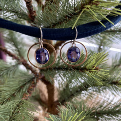 Faceted tanzanite cubic zirconia ovals sparkle in the center of 14K gold hoops. Crafted and donated by Judy Willingham.  