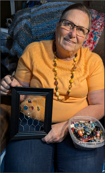 Kelley Boland of  Junction City strings salvaged beads on framed chicken wire.