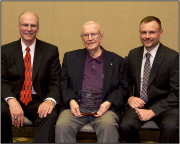 John Mann (center) holds Manhattan Legacy Award accompanied by Dr. Ralph Richardson (left) and Lonnie Baker (right). 