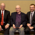 John Mann (center) holds Manhattan Legacy Award accompanied by Dr. Ralph Richardson (left) and Lonnie Baker (right). 